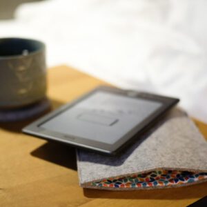 A table with a tablet and a cup on it