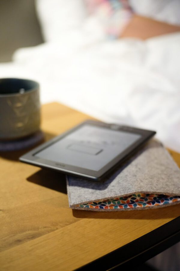 A table with a tablet and a cup on it